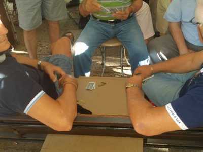 I frequentatori del giardino Lubich mentre giocano su un cartone, trasformato per l'occasione in un tavolo da gioco 